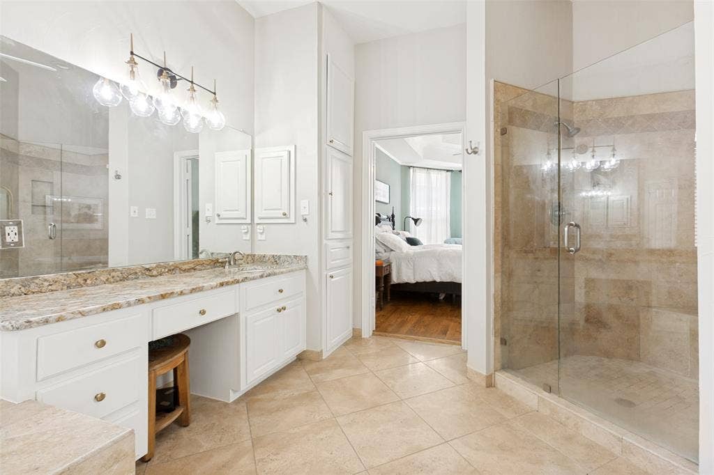2632 Barrington Drive, Plano, TX 75093 Bathroom featuring a glass-enclosed shower, dual vanity with a stone countertop, built-in cabinetry, and tile flooring