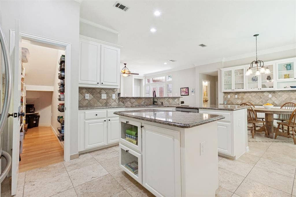 2632 Barrington Drive, Plano, TX 75093 Spacious kitchen featuring an island, white cabinetry, granite countertops, and tile flooring