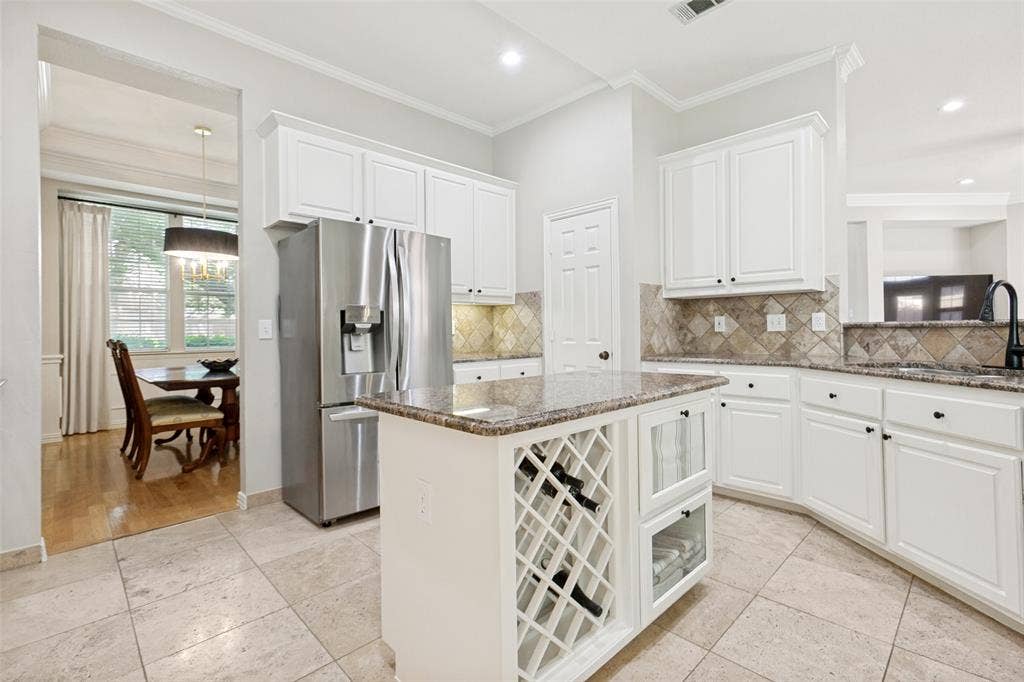 2632 Barrington Drive, Plano, TX 75093 Kitchen with white cabinetry, stainless steel refrigerator, granite countertops, and tiled backsplash