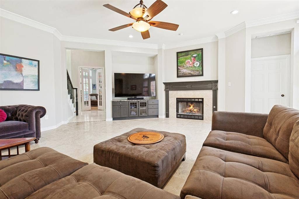 2632 Barrington Drive, Plano, TX 75093 Spacious living area featuring a central fireplace with a stone surround and dark wood mantel