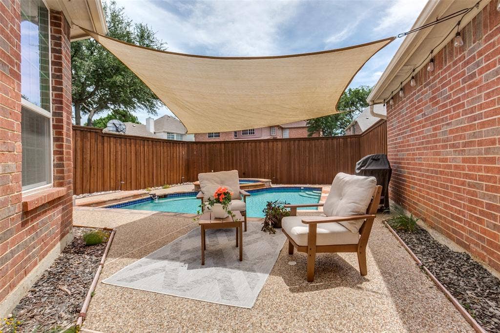 2632 Barrington Drive, Plano, TX 75093 Backyard oasis featuring a swimming pool with integrated spa, a shade sail, and exposed aggregate patio