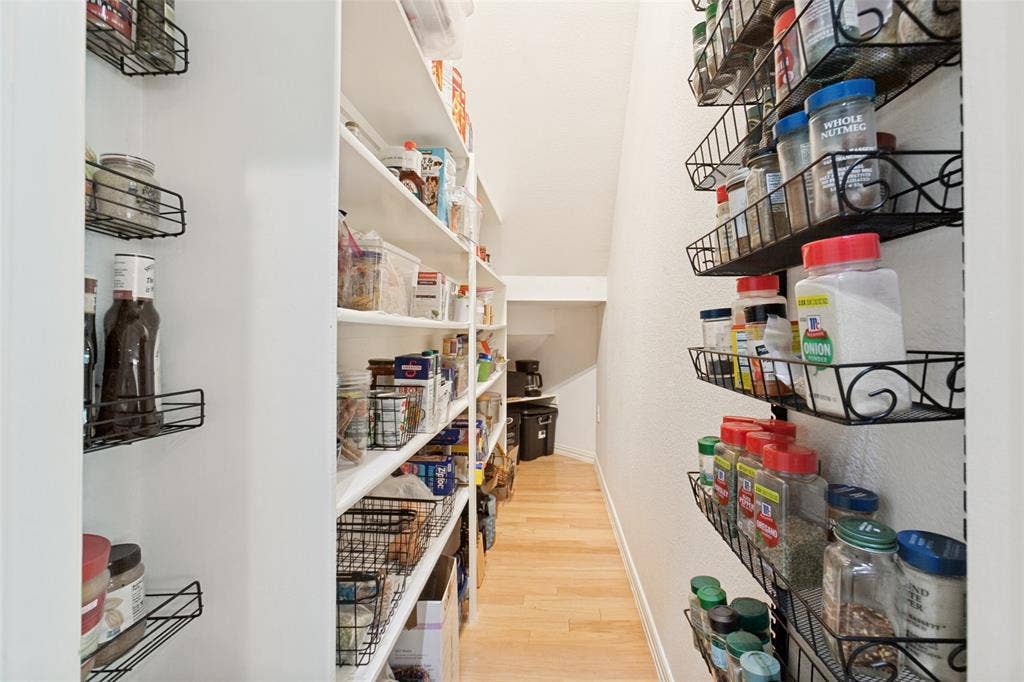 2632 Barrington Drive, Plano, TX 75093 Spacious walk-in pantry featuring extensive built-in shelving, wall-mounted spice racks, and wood-finish flooring