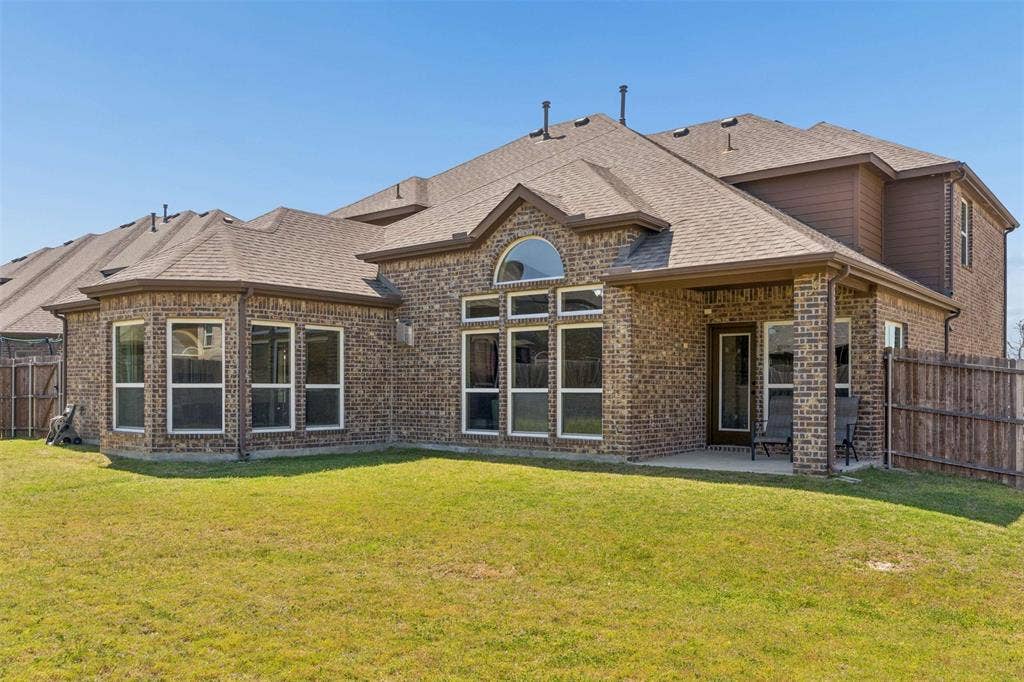 2446 Old Stables Drive, Celina, TX 75009 Rear view of property with a fenced backyard, a patio, brick siding, and a shingled roof