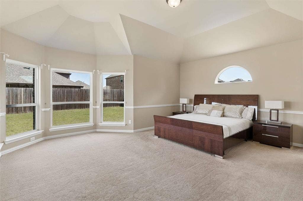 2446 Old Stables Drive, Celina, TX 75009 Bedroom featuring light colored carpet, multiple windows, and vaulted ceiling