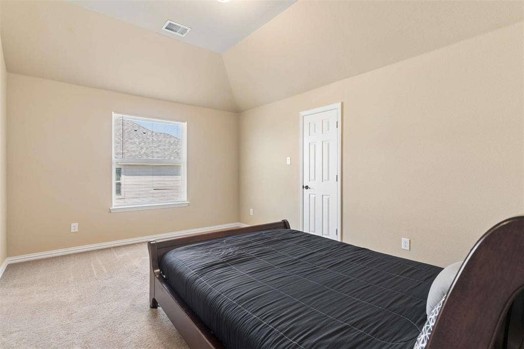 2446 Old Stables Drive, Celina, TX 75009 Bedroom featuring light carpet and lofted ceiling