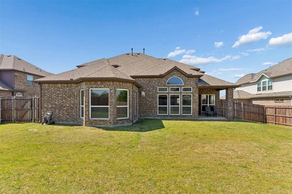 2446 Old Stables Drive, Celina, TX 75009 Rear view of house featuring brick siding, a shingled roof, a fenced backyard, and a patio