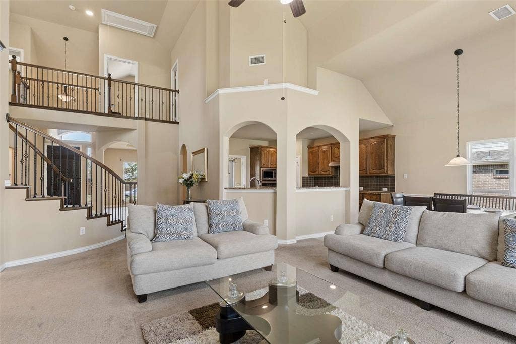 2446 Old Stables Drive, Celina, TX 75009 Living room with carpet floors, a high ceiling, arched walkways, and ceiling fan