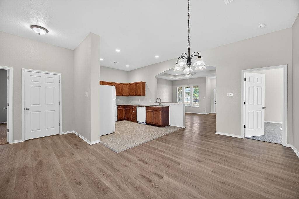 625 Green Mound Drive, Glenn Heights, TX 75154 Kitchen featuring open floor plan, a peninsula, light countertops, white appliances, and wood finish cabinets