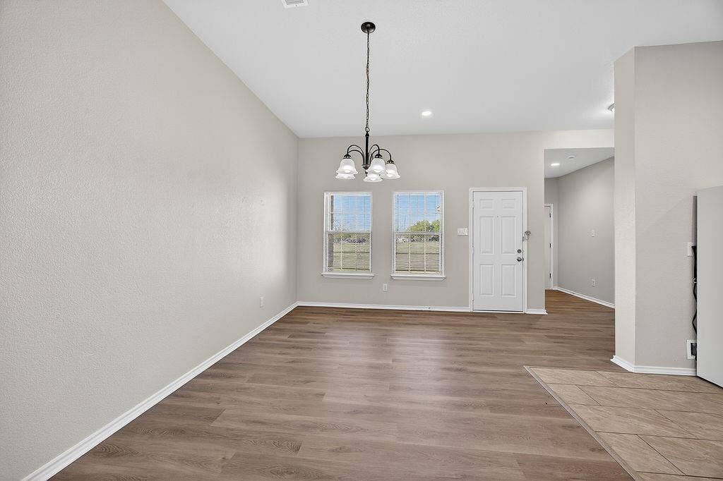 625 Green Mound Drive, Glenn Heights, TX 75154 Unfurnished dining area featuring dark wood-style floors and suspended lighting