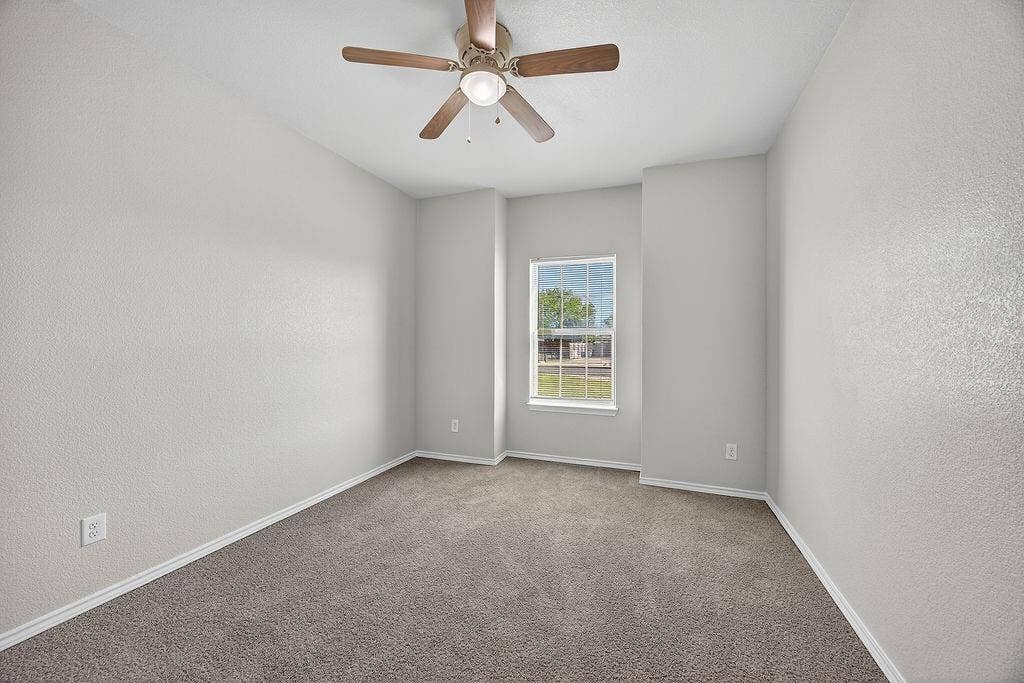 625 Green Mound Drive, Glenn Heights, TX 75154 Empty room featuring a textured wall, a ceiling fan, and carpet floors