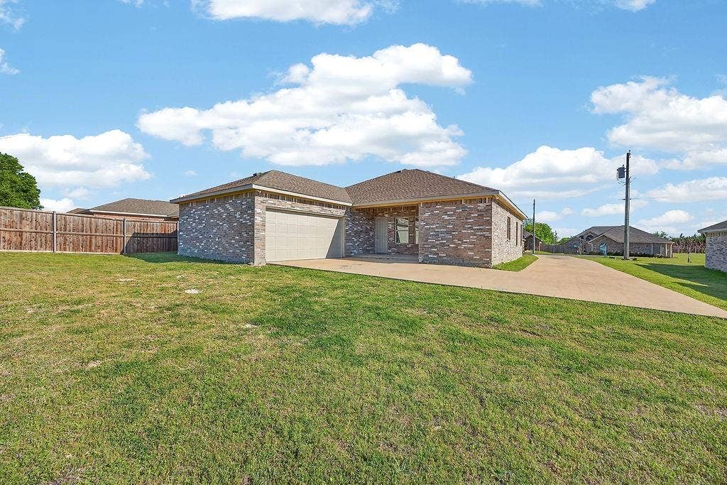 625 Green Mound Drive, Glenn Heights, TX 75154 View of side of home featuring a garage, brick siding, and concrete driveway