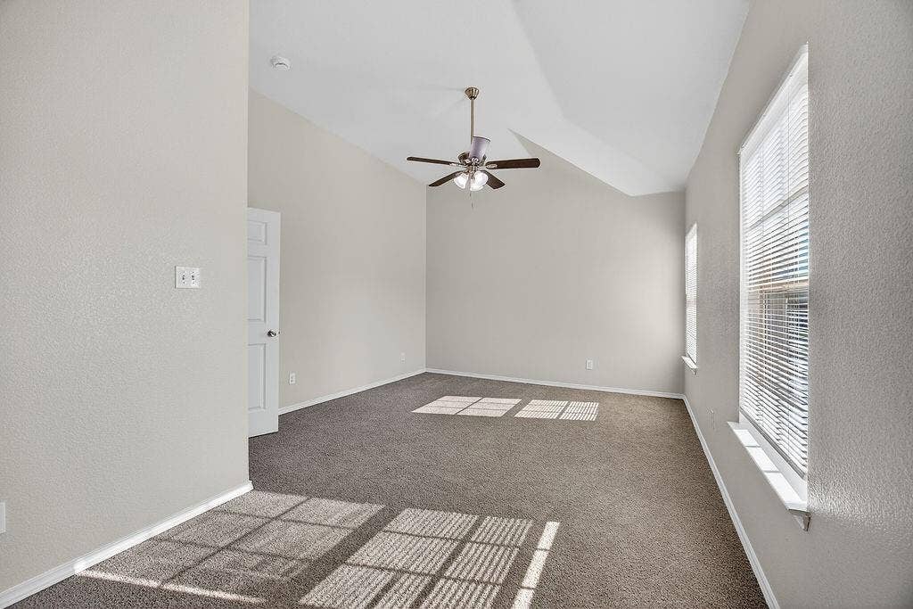 625 Green Mound Drive, Glenn Heights, TX 75154 Spare room featuring a ceiling fan, lofted ceiling, and dark colored carpet