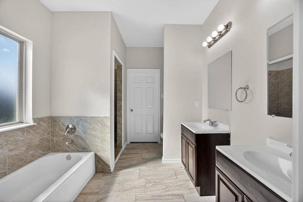 625 Green Mound Drive, Glenn Heights, TX 75154 Full bathroom featuring two vanities, plenty of natural light, a garden tub, and light marble finish floors