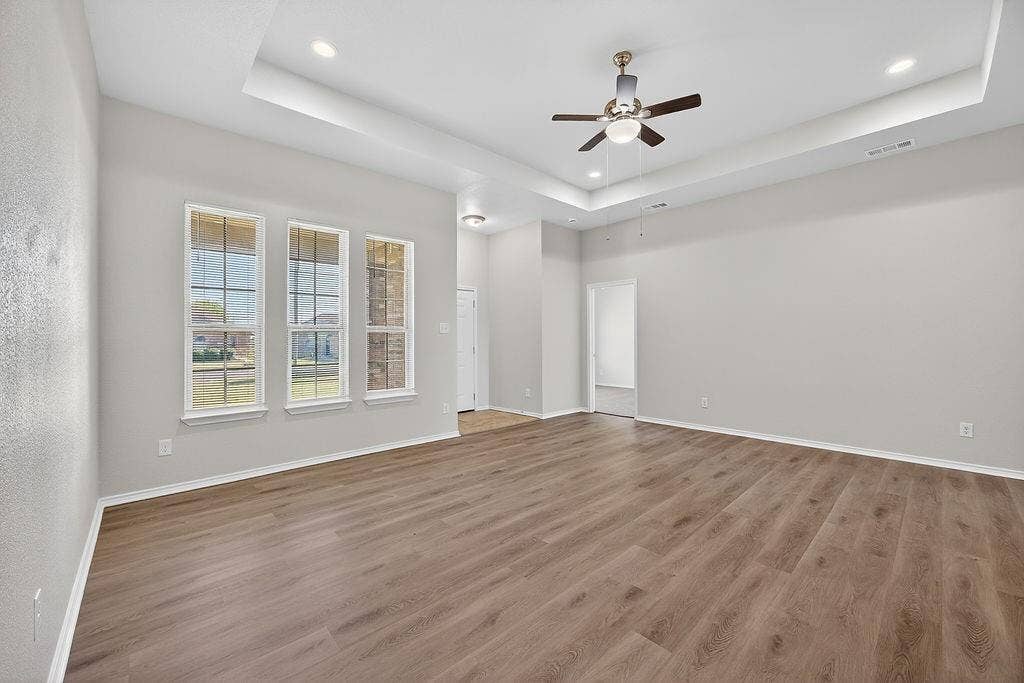 625 Green Mound Drive, Glenn Heights, TX 75154 Spare room featuring ceiling fan, a tray ceiling, wood finished floors, and recessed lighting