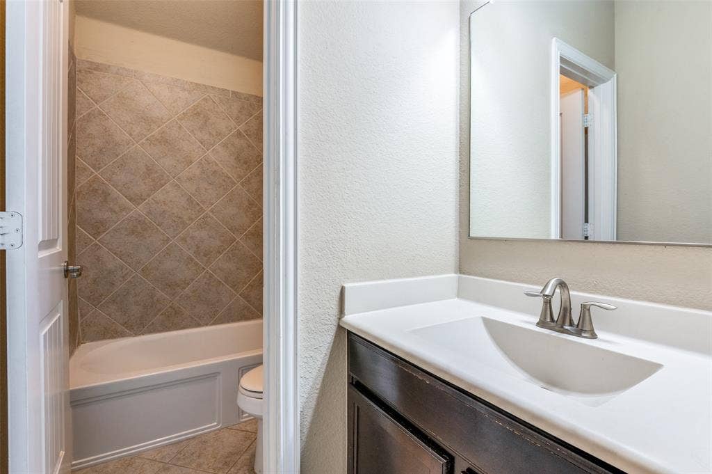 16425 Toledo Bend Court, Prosper, TX 75078 Full bathroom with vanity, a textured wall, and light tile patterned floors