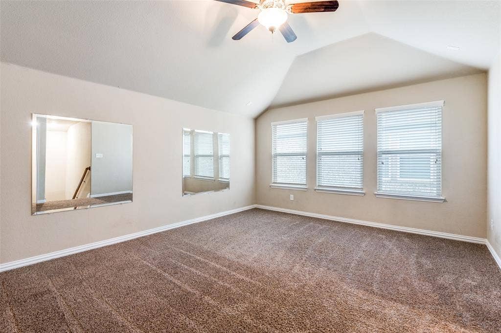 16425 Toledo Bend Court, Prosper, TX 75078 Spare room featuring ceiling fan, dark colored carpet, and lofted ceiling