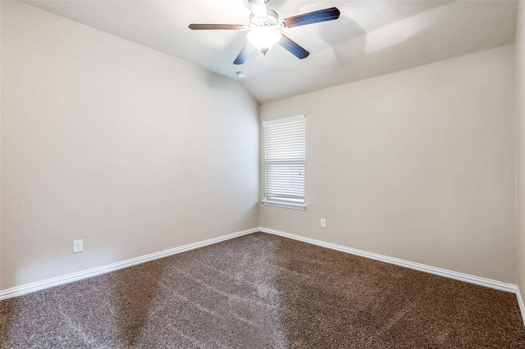 16425 Toledo Bend Court, Prosper, TX 75078 Empty room featuring lofted ceiling, dark carpet, and ceiling fan