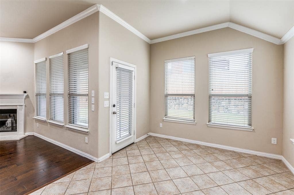 16425 Toledo Bend Court, Prosper, TX 75078 Entryway featuring ornamental molding, light tile patterned floors, a glass covered fireplace, and vaulted ceiling