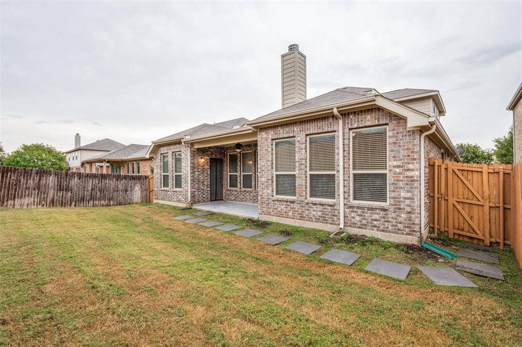 16425 Toledo Bend Court, Prosper, TX 75078 Rear view of house with a gate, brick siding, a patio, a fenced backyard, and a chimney
