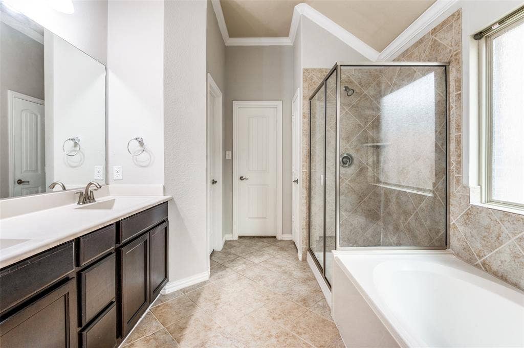 16425 Toledo Bend Court, Prosper, TX 75078 Full bathroom with ornamental molding, a shower stall, a bath, double vanity, and plenty of natural light