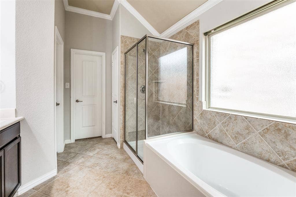 16425 Toledo Bend Court, Prosper, TX 75078 Full bathroom featuring crown molding, vanity, a bath, a shower stall, and light tile patterned flooring