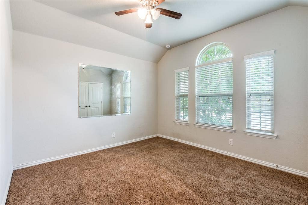 16425 Toledo Bend Court, Prosper, TX 75078 Unfurnished room with vaulted ceiling, a ceiling fan, and dark carpet