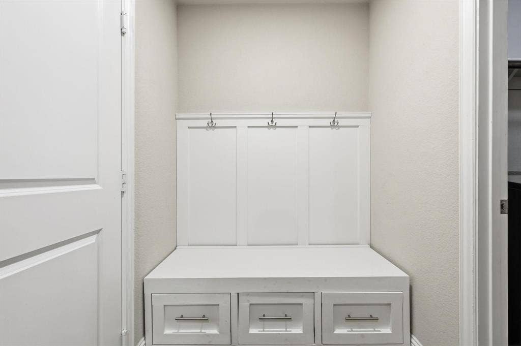 1212 Mount Olive Lane, Forney, TX 75126 Built-in mudroom bench with three storage drawers, integrated coat hooks, and crisp white paneling