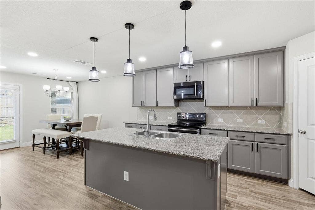 1212 Mount Olive Lane, Forney, TX 75126 Modern kitchen featuring a central island with a double basin sink and pendant lighting