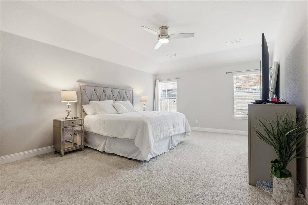 1212 Mount Olive Lane, Forney, TX 75126 Primary bdrm featuring light-toned walls, plush carpeting, and a ceiling fan with integrated lighting