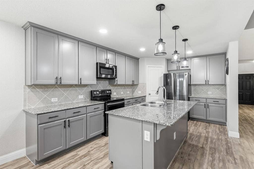 1212 Mount Olive Lane, Forney, TX 75126 Kitchen featuring grey cabinetry, granite countertops, and stainless steel appliances including a microwave and range