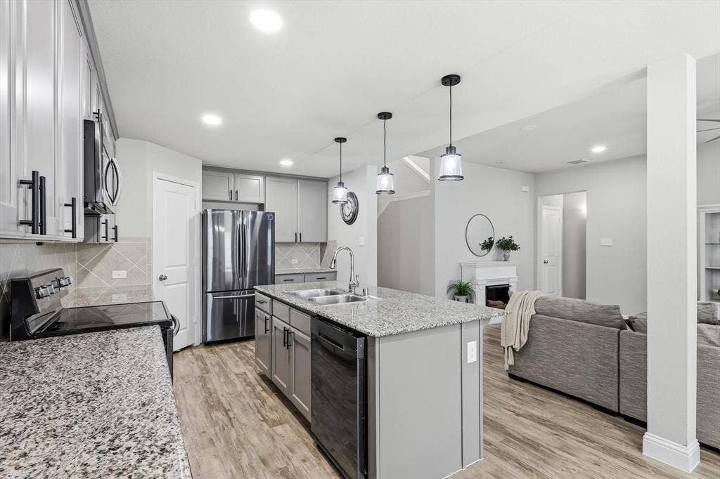 1212 Mount Olive Lane, Forney, TX 75126 Open-concept kitchen featuring granite countertops, stainless steel appliances, a central island with pendant lighting, and wood-finish flooring