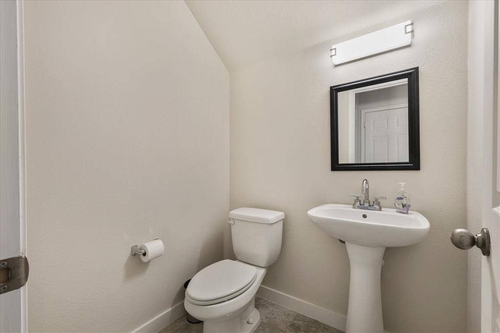 3025 Stone Forest Circle, McKinney, TX 75070 Half bath featuring toilet and lofted ceiling