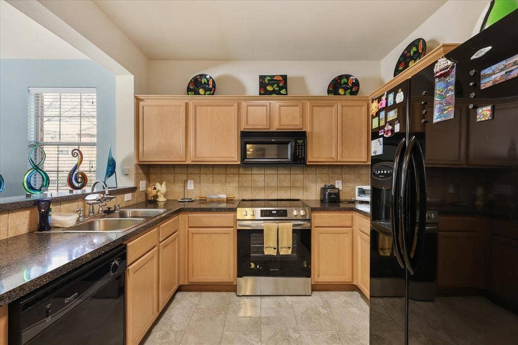 3025 Stone Forest Circle, McKinney, TX 75070 Kitchen featuring black appliances, decorative backsplash, light wood finish cabinetry, and a peninsula
