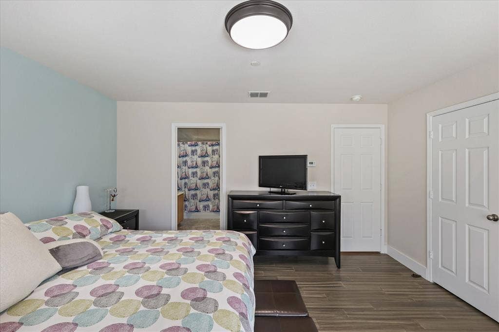 3025 Stone Forest Circle, McKinney, TX 75070 Bedroom with dark wood-style flooring and ensuite bathroom