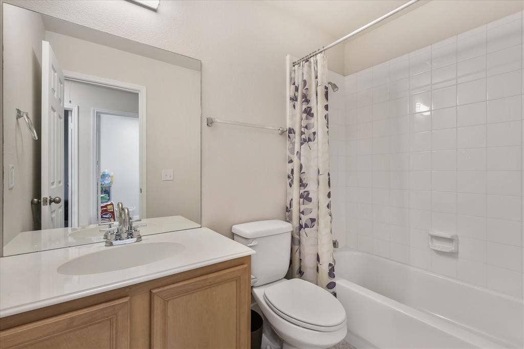 3025 Stone Forest Circle, McKinney, TX 75070 Bathroom with vanity and shower / bathtub combination with curtain