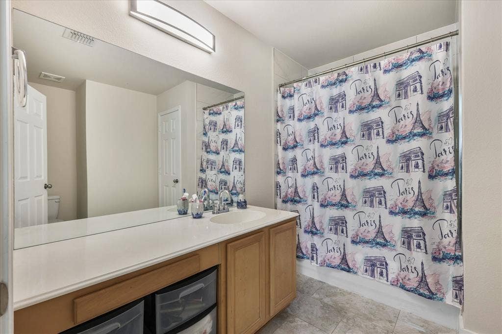 3025 Stone Forest Circle, McKinney, TX 75070 Full bathroom featuring vanity, shower / bath combination with curtain, and light tile patterned flooring