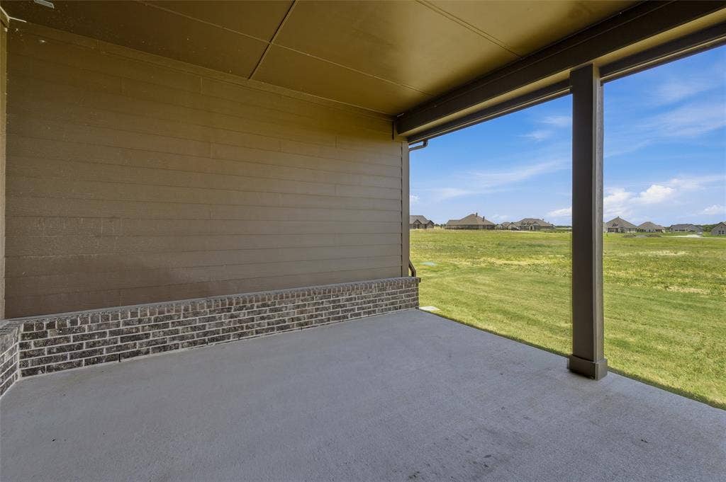 2408 Quartz Street, Krum, TX 76249 Covered patio featuring a concrete slab floor, a brick wainscoting, and siding walls