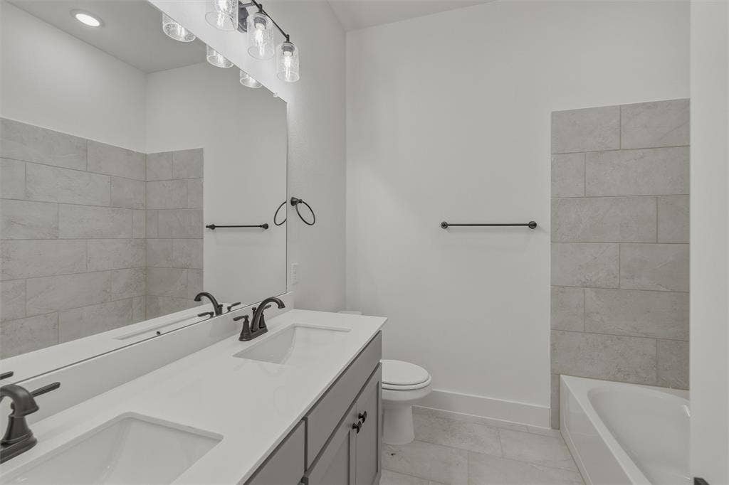 2408 Quartz Street, Krum, TX 76249 Contemporary bathroom featuring a double vanity with an integrated countertop, dark bronze fixtures, and a large wall mirror
