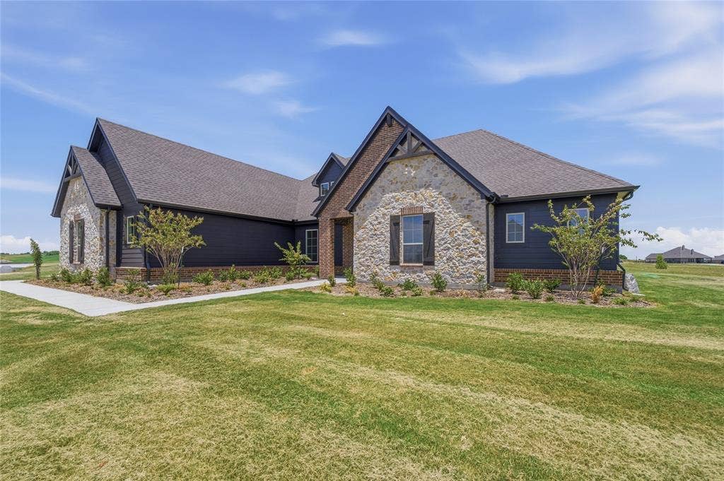 2305 Gypsum Street, Krum, TX 76249 Contemporary exterior featuring dark siding, stone accents, gabled rooflines, and a concrete pathway