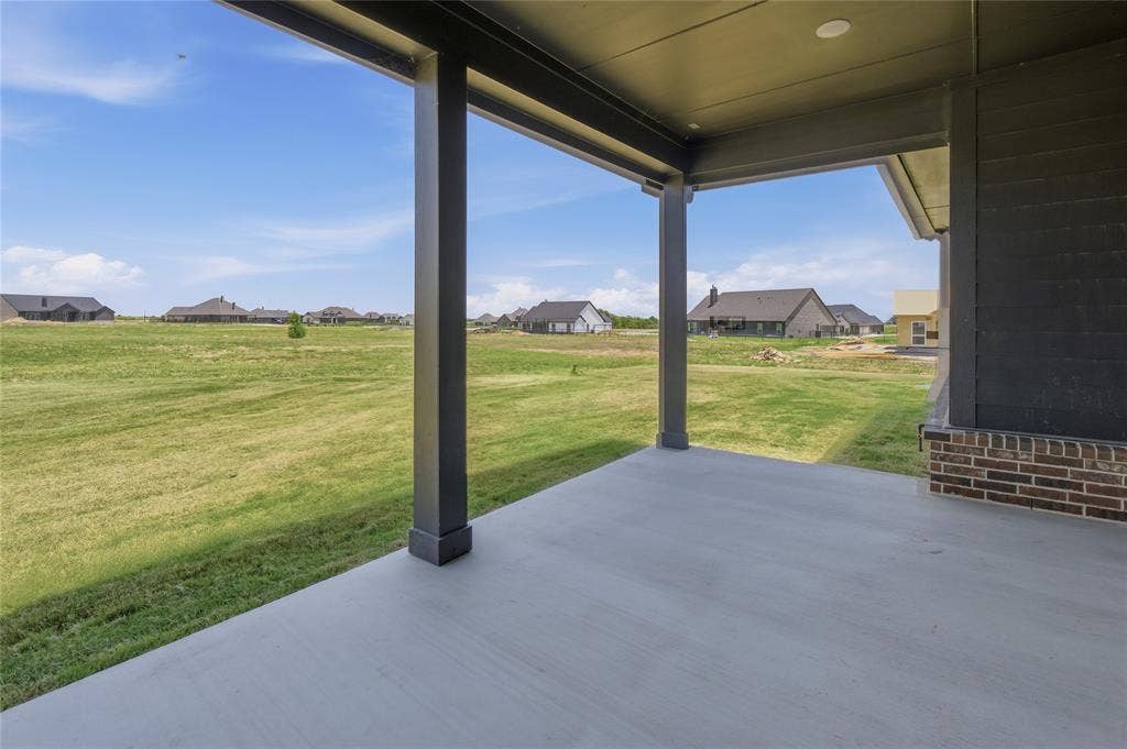 2305 Gypsum Street, Krum, TX 76249 Covered outdoor patio with a concrete surface, supported by dark-toned columns