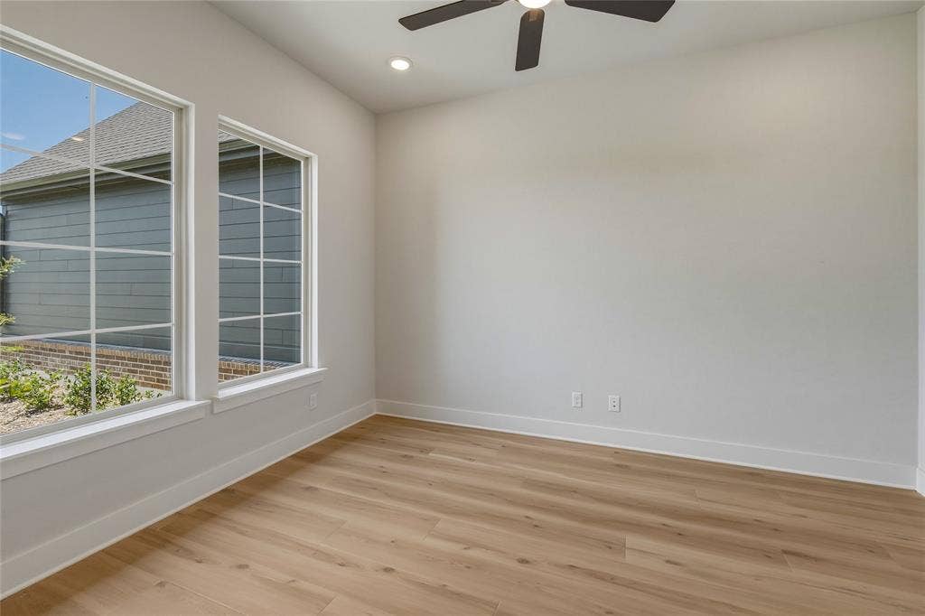 2305 Gypsum Street, Krum, TX 76249 Room with wood-finish flooring, two large windows with grid patterns, a ceiling fan, and recessed lighting