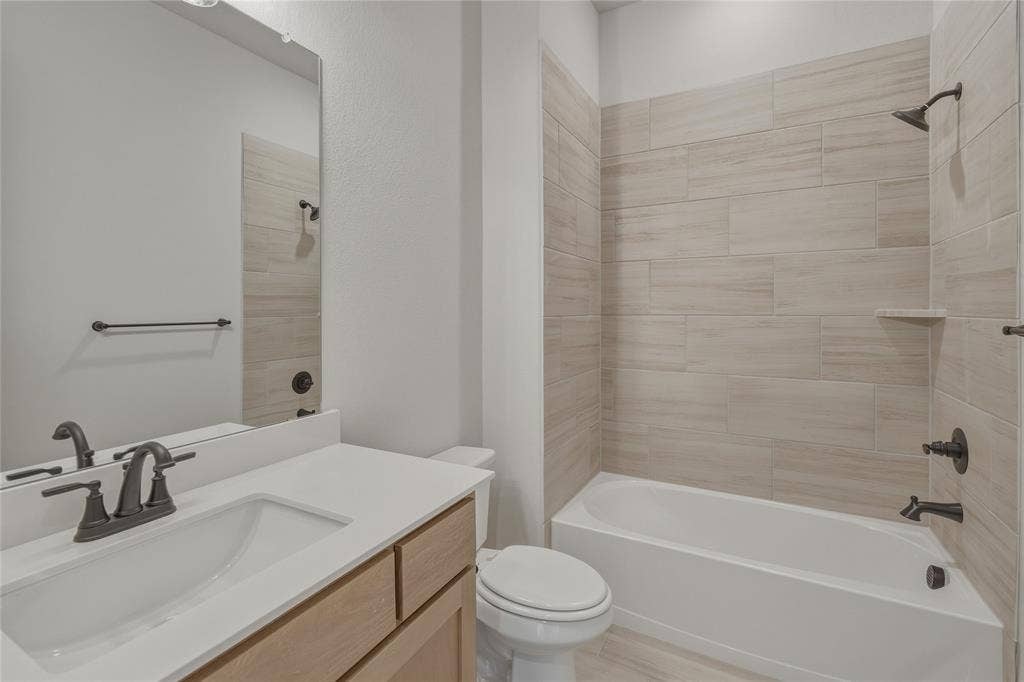 2305 Gypsum Street, Krum, TX 76249 Bathroom featuring a vanity with light wood-finish cabinetry, a white countertop, and an undermount sink with dark bronze fixtures