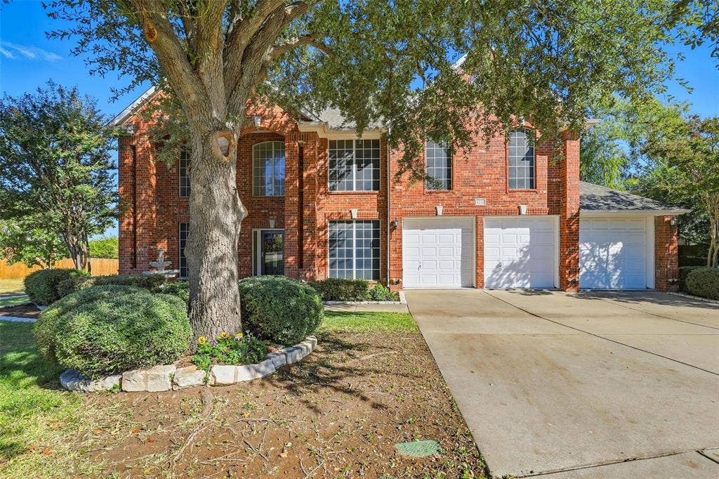 5212 Whisper Drive, Fort Worth, TX 76123 View of front facade featuring concrete driveway, brick siding, and a garage