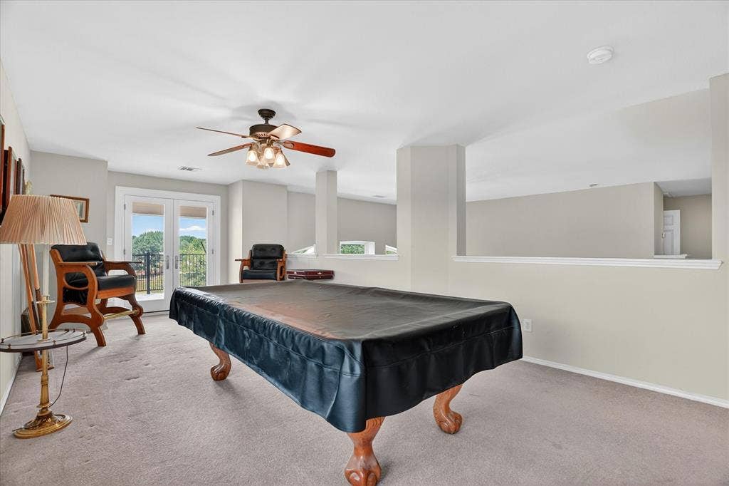 5212 Whisper Drive, Fort Worth, TX 76123 Spacious entertainment area featuring carpet flooring, an open wall cut-out, ceiling fan with integrated lighting, and a double-door exterior entrance