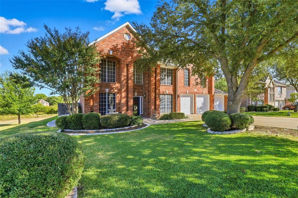 5212 Whisper Drive, Fort Worth, TX 76123 View of front of home with brick siding, a front lawn, driveway, and an attached garage