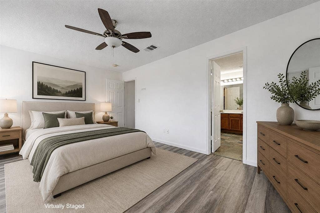 Bedroom featuring wood-finish flooring, a ceiling fan with integrated lighting, and a neutral color palette