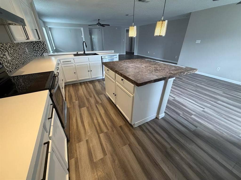 Modern kitchen featuring white cabinetry, dark hardware, and a mosaic tile backsplash