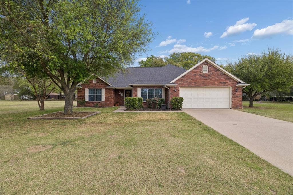 25 Starview Drive, Star Harbor, TX 75148 Single story home featuring brick siding, a front lawn, a garage, concrete driveway, and roof with shingles