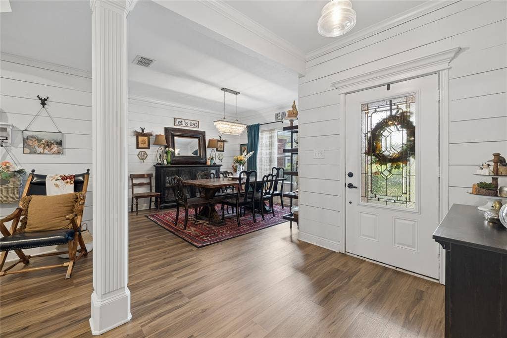 25 Starview Drive, Star Harbor, TX 75148 Foyer entrance with ornate column, wooden walls, wood flooring, and ornamental molding