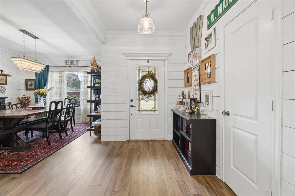 25 Starview Drive, Star Harbor, TX 75148 Entrance foyer featuring wood walls, wood flooring, crown molding, and hanging lights
